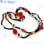 Load image into Gallery viewer, Red coral beaded necklace with black beads and silver accents on a white background, showcasing the jewelry's design