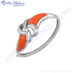 Load image into Gallery viewer, Silver bangle bracelet featuring a central coral stone and diamond accents, a beautiful piece of luxury jewelry.