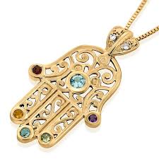 A gold necklace with a hamsa on it