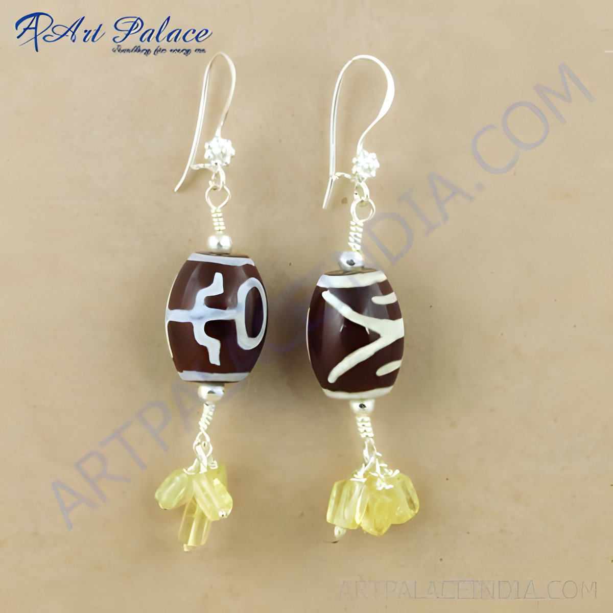 Silver dzi bead dangle earrings with yellow gemstone accents, brown and white beads, and silver hooks