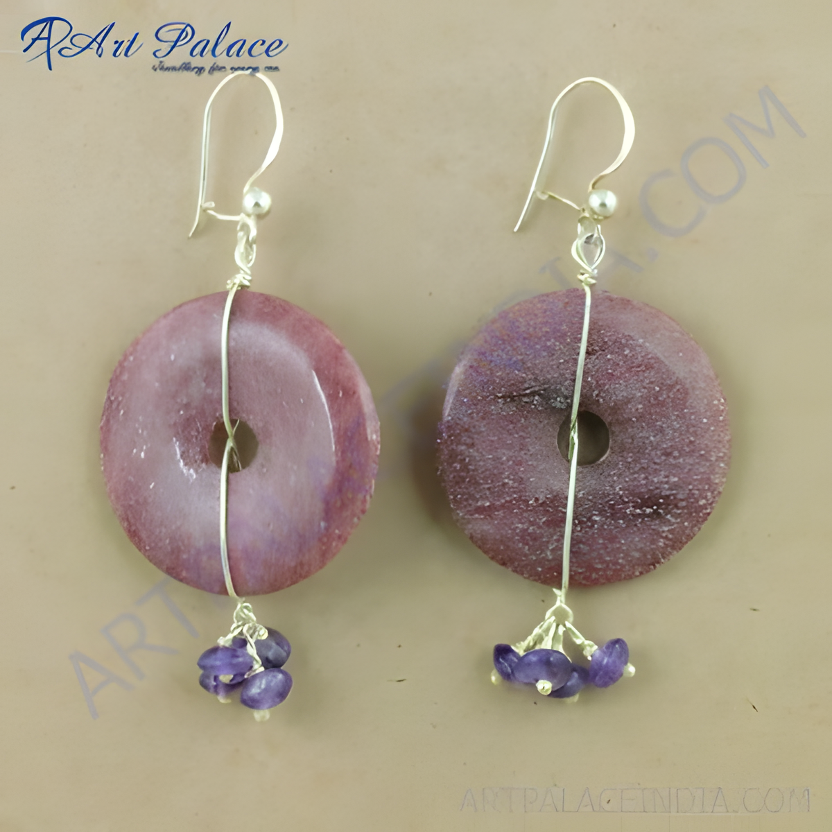 Sterling silver dangle earrings featuring a donut shaped pink stone and small amethyst beads