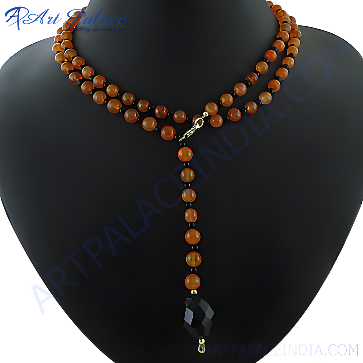 Carnelian bead lariat necklace on a black jewelry display, featuring orange gemstone beads and a geometric black pendant