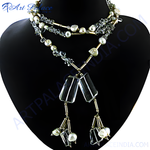 Load image into Gallery viewer, Elegant pearl and crystal pendant necklace displayed on a black mannequin, featuring a layered design with shimmering elements.
