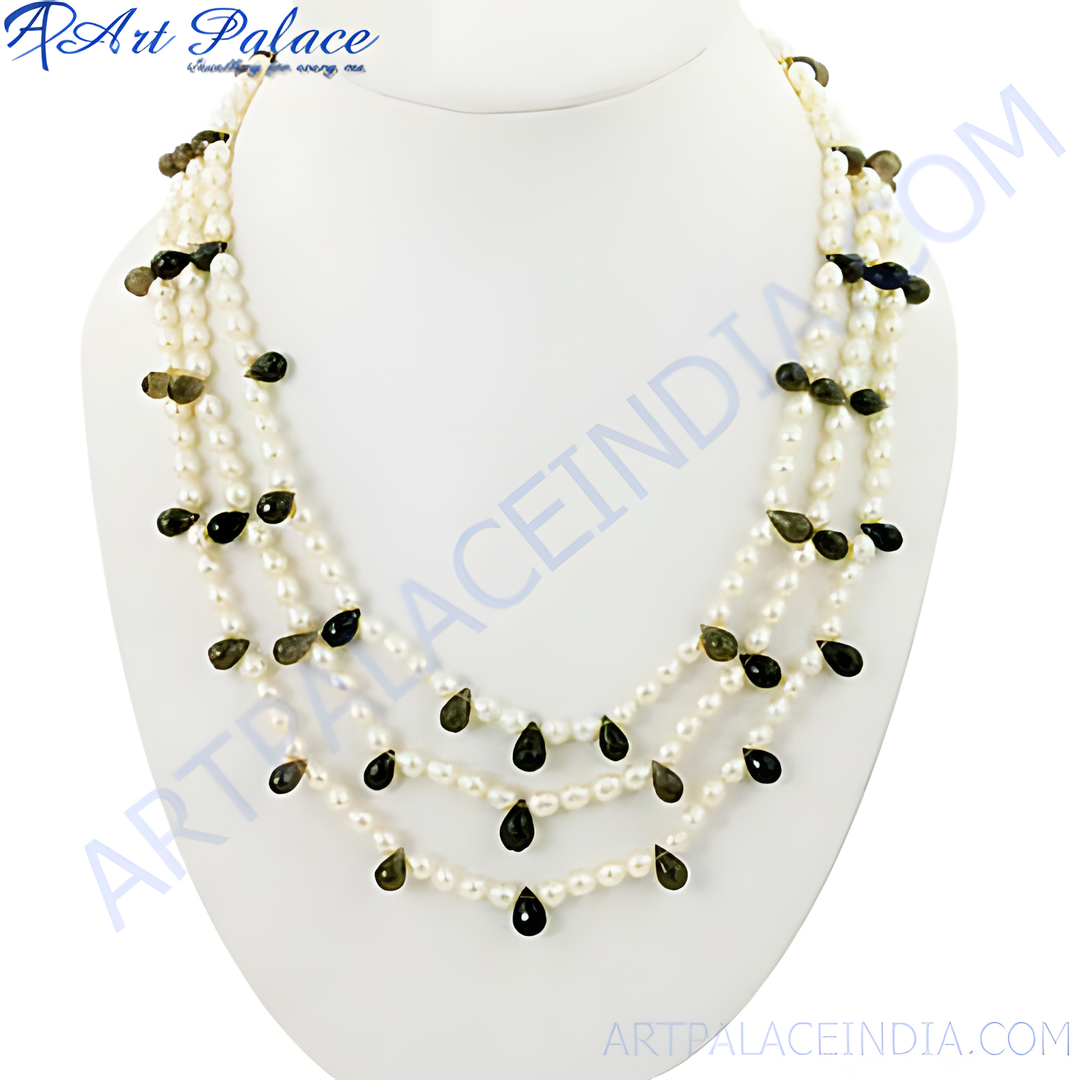 Pearl and gemstone beaded necklace on a white display stand. Features white pearls and dark teardrop-shaped gemstones.