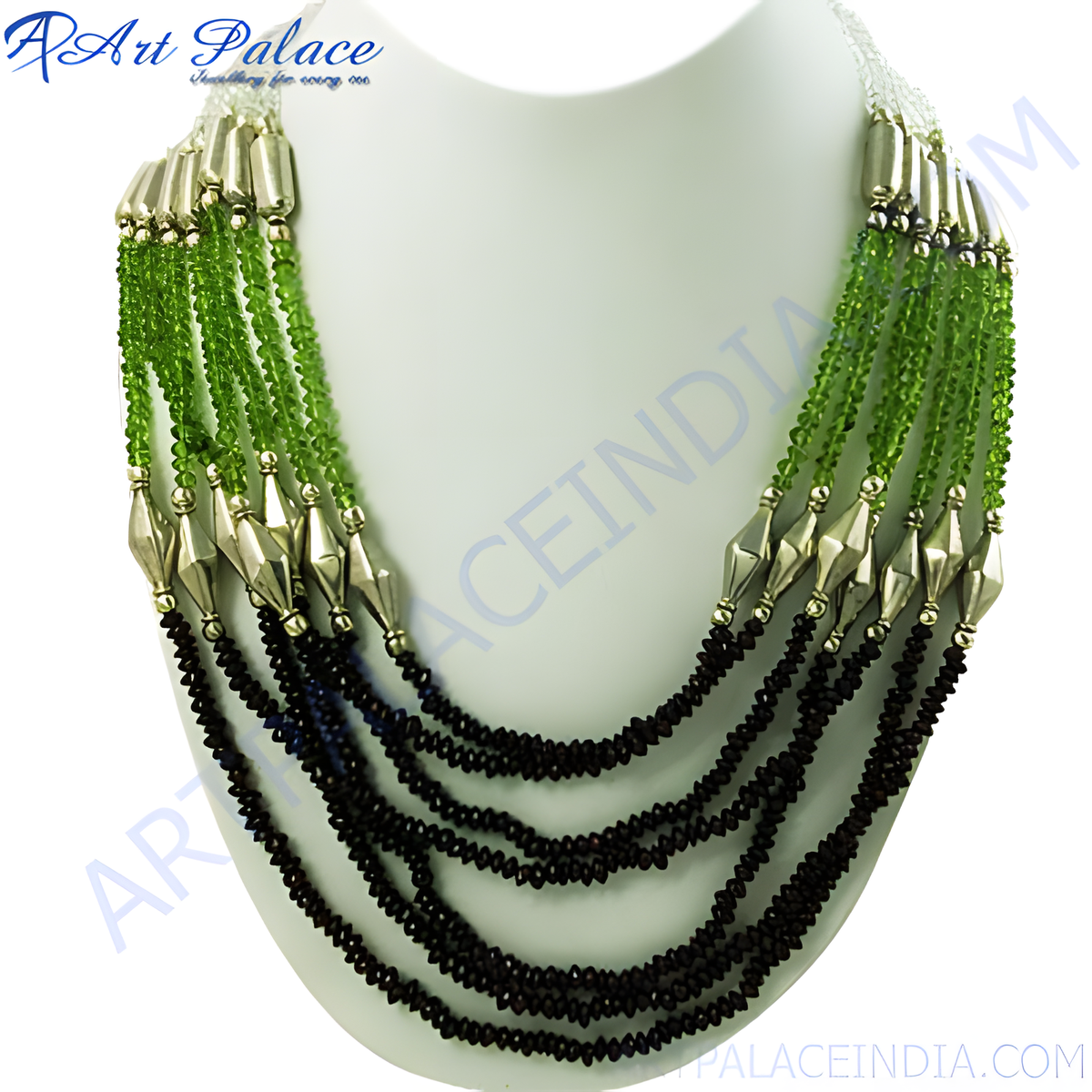 Multi strand necklace featuring green and black beads on a white mannequin