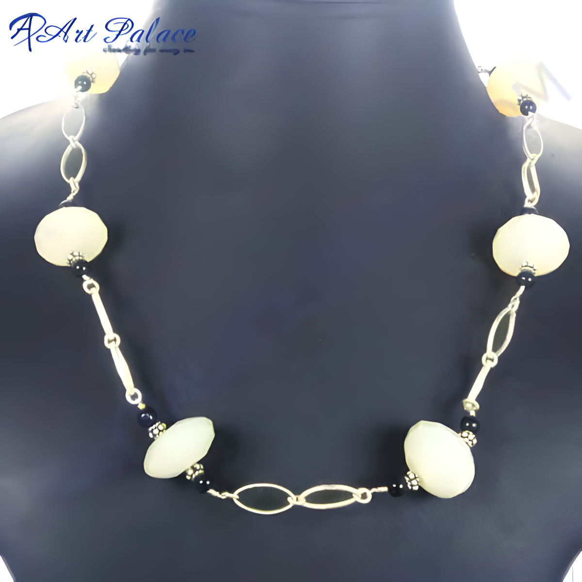 Cream colored beaded statement necklace with silver accents displayed on a mannequin