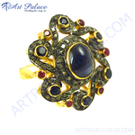 Load image into Gallery viewer, Oxidized gold plating ring featuring a large sapphire center stone and ruby accents in a floral design.
