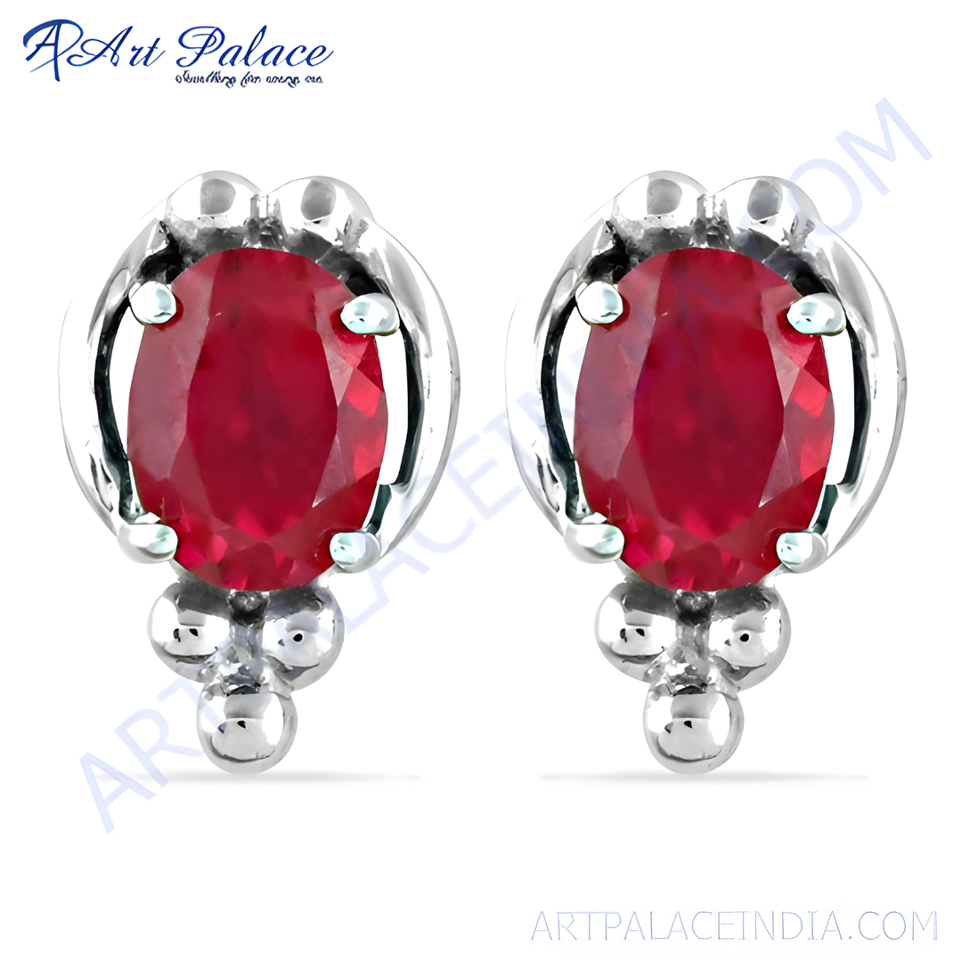 Silver stud earrings featuring oval-cut ruby gemstones. Elegant red stone earrings for women.