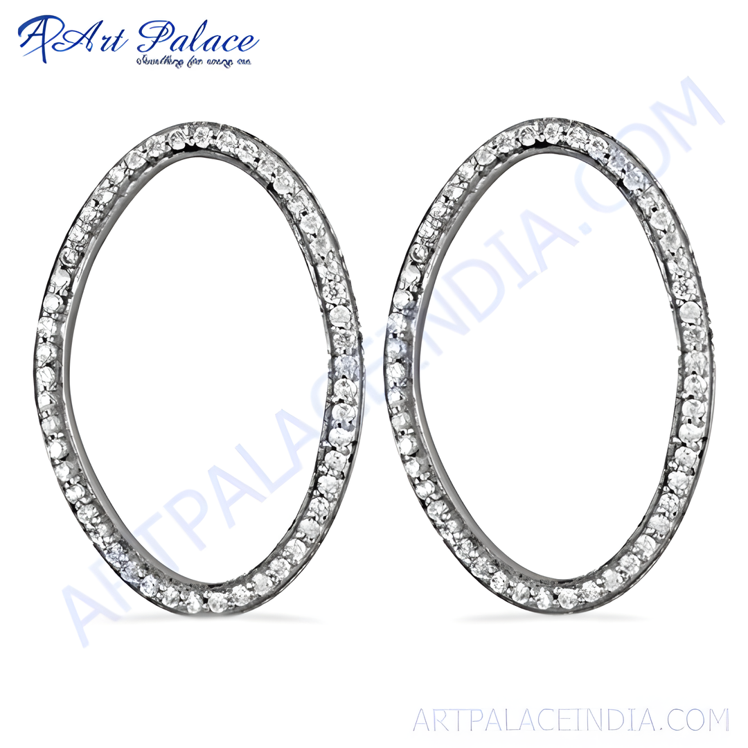 Silver oval hoop earrings with sparkling diamonds on a white background, showcasing elegant women's jewelry.