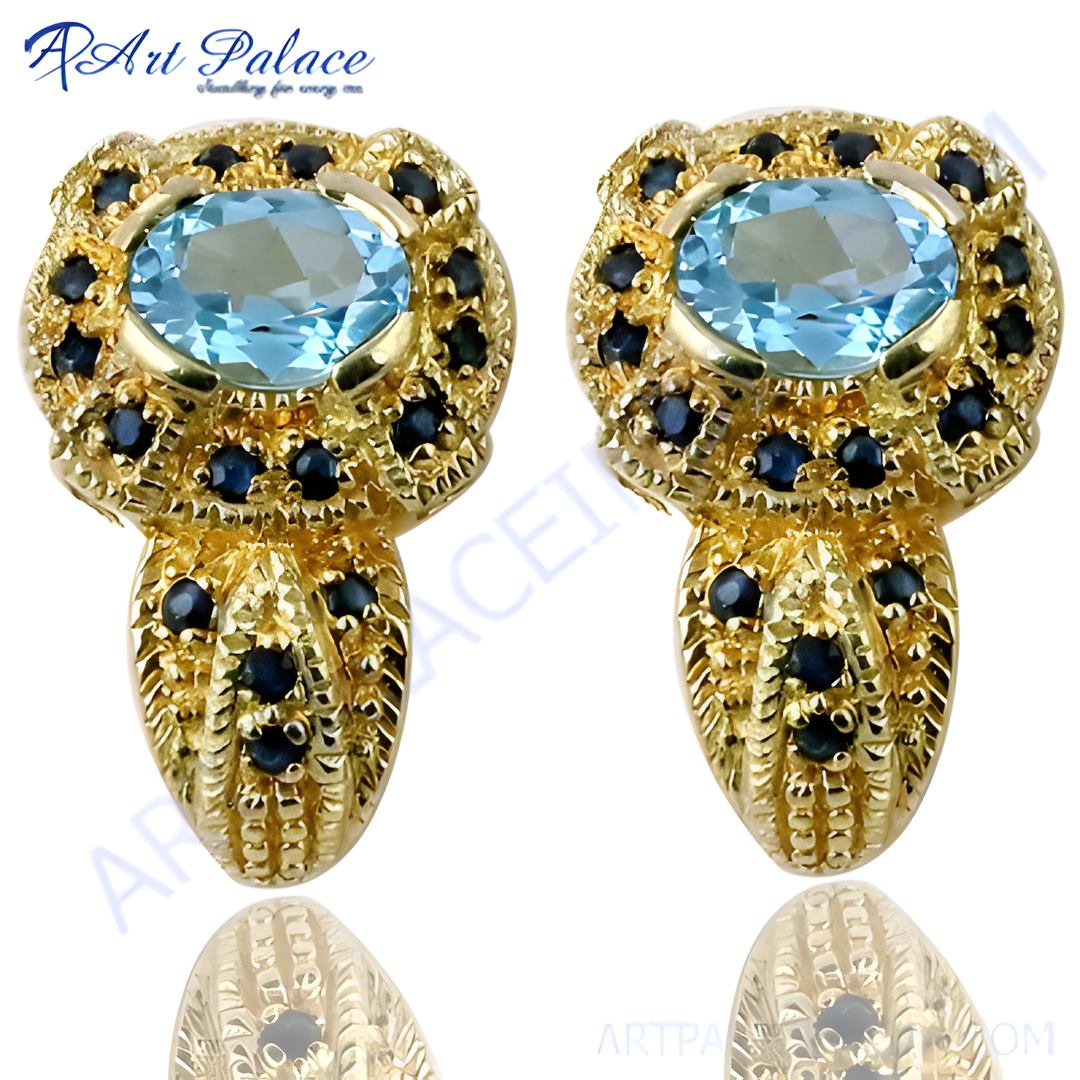 gold plating stud earrings with a large oval blue topaz center stone and sapphire accents