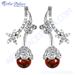 Load image into Gallery viewer, Silver drop earrings with red gemstone, a floral design on a white background.
