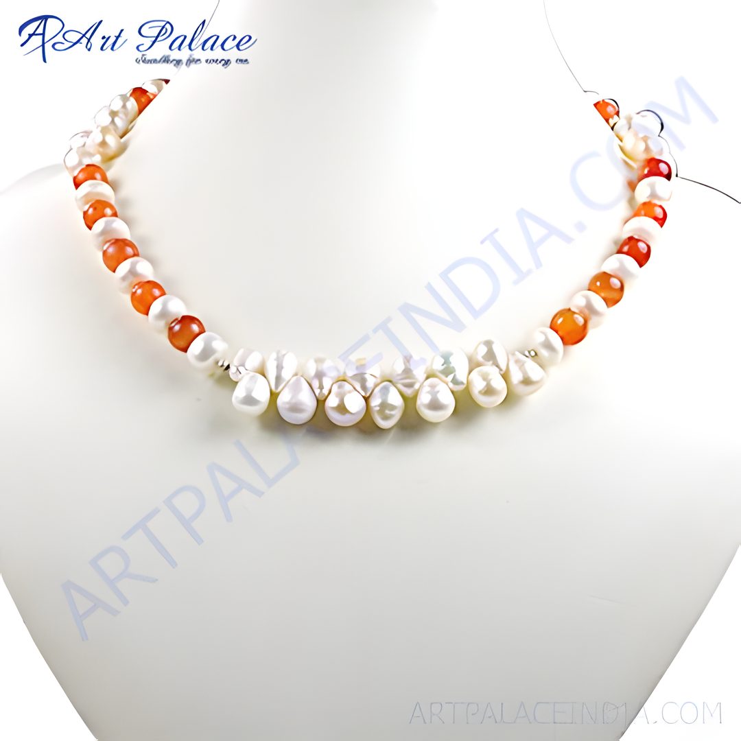 A necklace featuring white pearls and orange carnelian beads on a white surface.