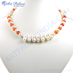 Load image into Gallery viewer, A necklace featuring white pearls and orange carnelian beads on a white surface.
