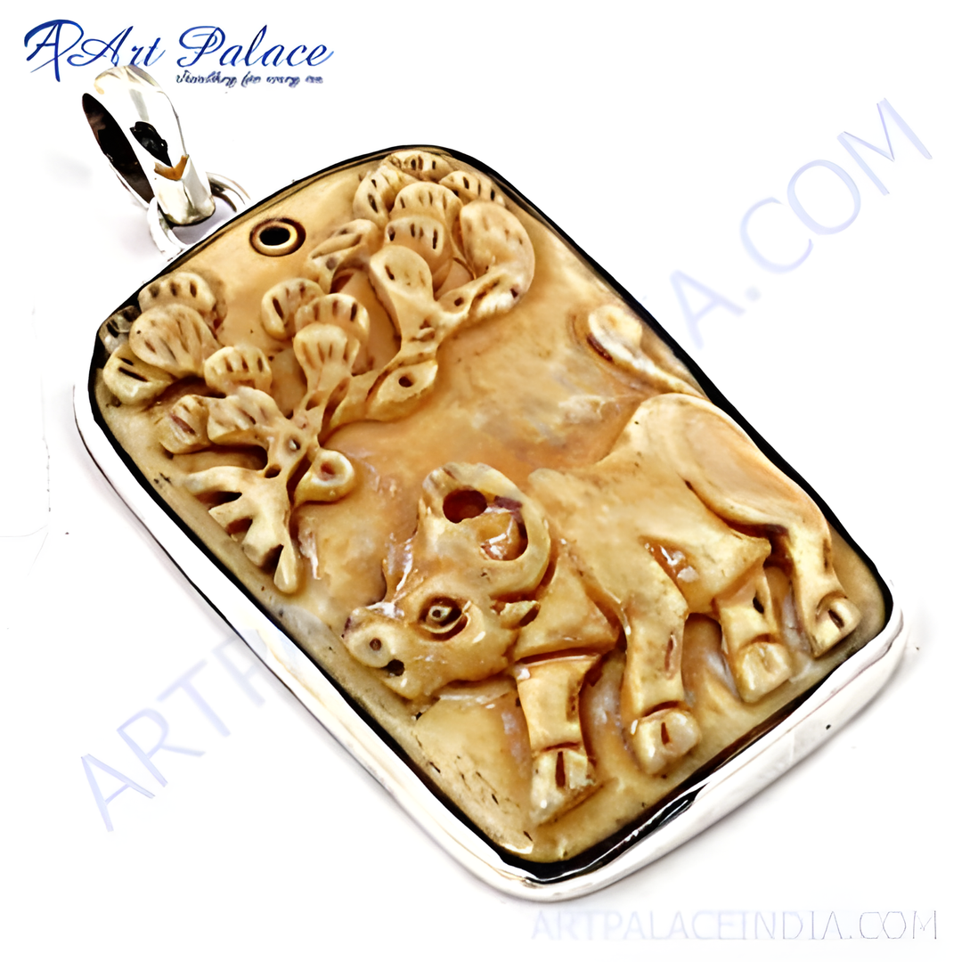 Sterling silver carved ox pendant with detailed animal carving on a beige background.
