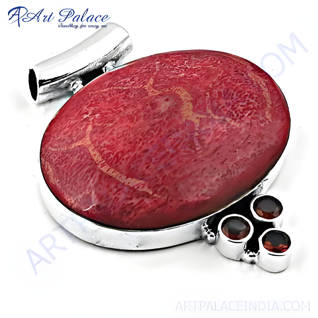 Silver pendant necklace with a large red coral gemstone and three garnet accents.