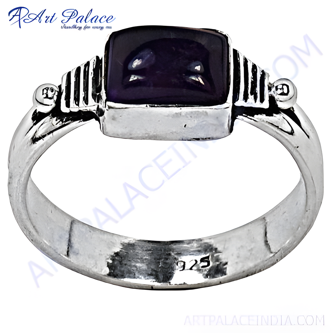 A sterling silver ring with a rectangular amethyst gemstone center in a close-up shot.