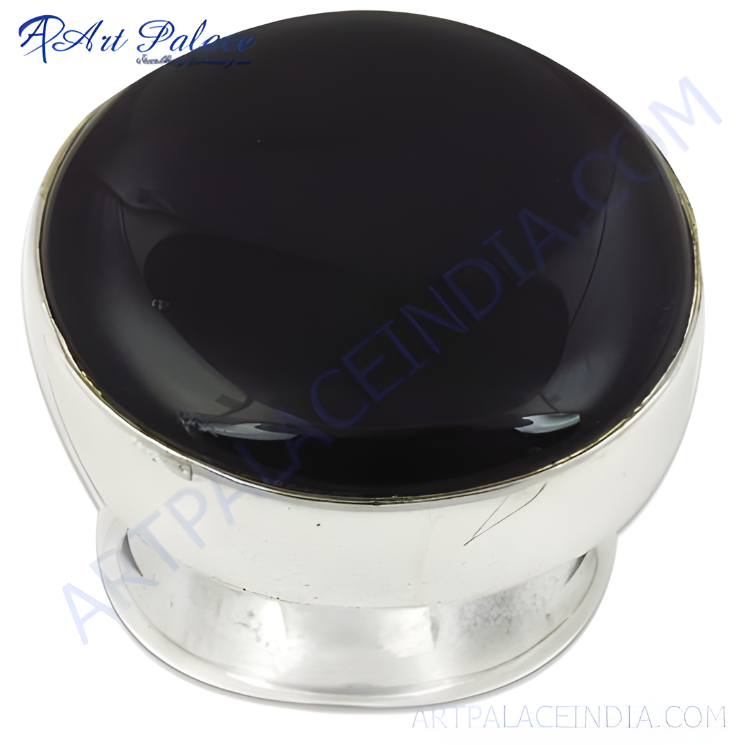 Close-up of a silver ring with a large, polished black onyx gemstone center.