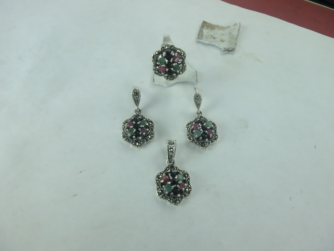Sterling silver gemstone ring and earrings set with red, green, and black stones.