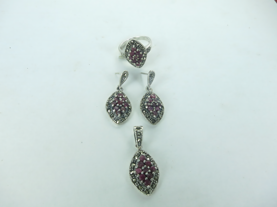 Sterling silver ring and earrings set with red rubies.
