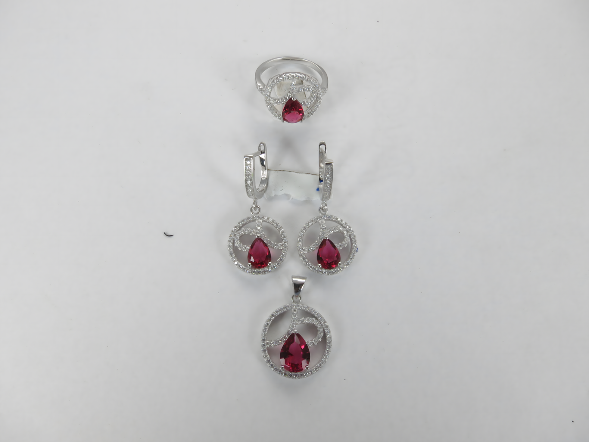 Sterling silver jewelry set with ruby red gemstones: ring, earrings, and pendant necklace