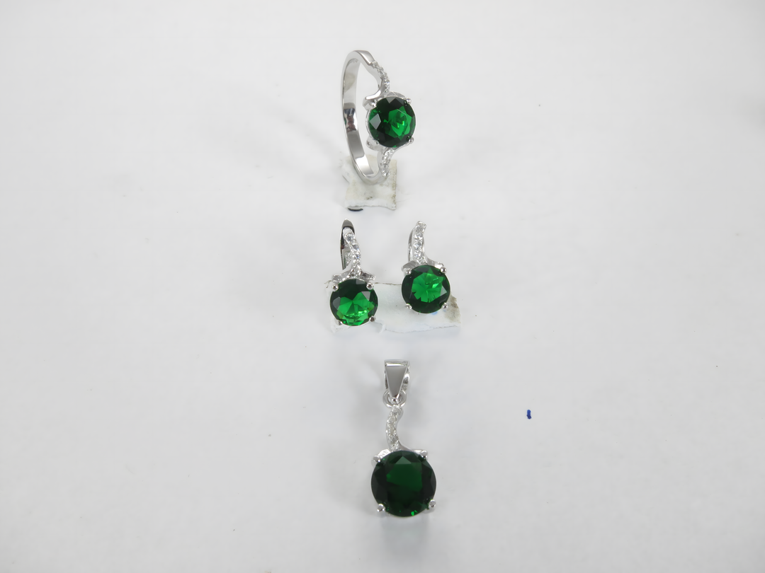 Sterling silver jewelry set with green gemstone ring, earrings, and pendant on a white background.