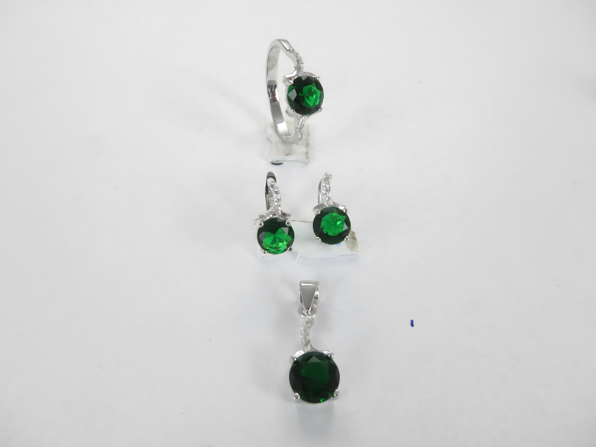 Sterling silver jewelry set with green gemstone ring, earrings, and pendant on a white background