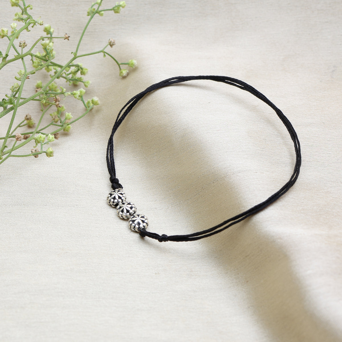 Black cord anklet with three floral sterling silver charms