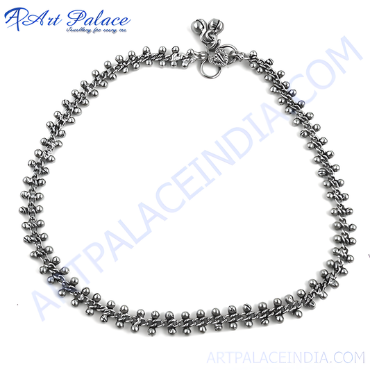 Oxidized silver chain anklet with beaded accents and bell charms, perfect for a bohemian look.