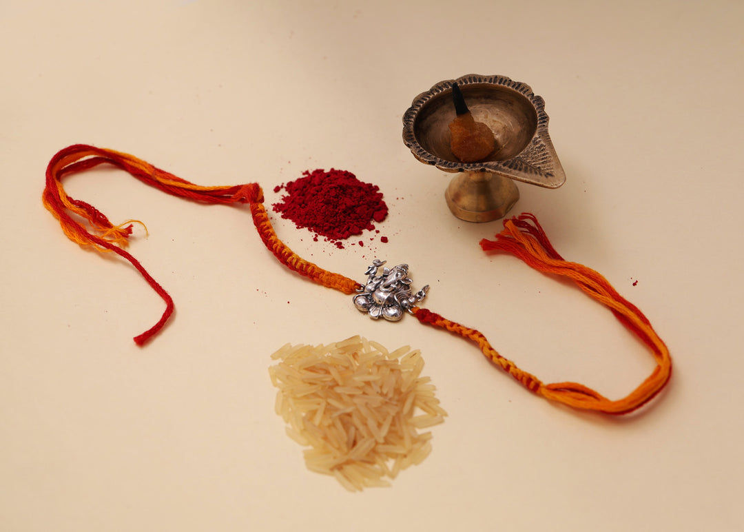 925 Sterling Silver Ganesha charm on a red and yellow thread Rakhi bracelet.